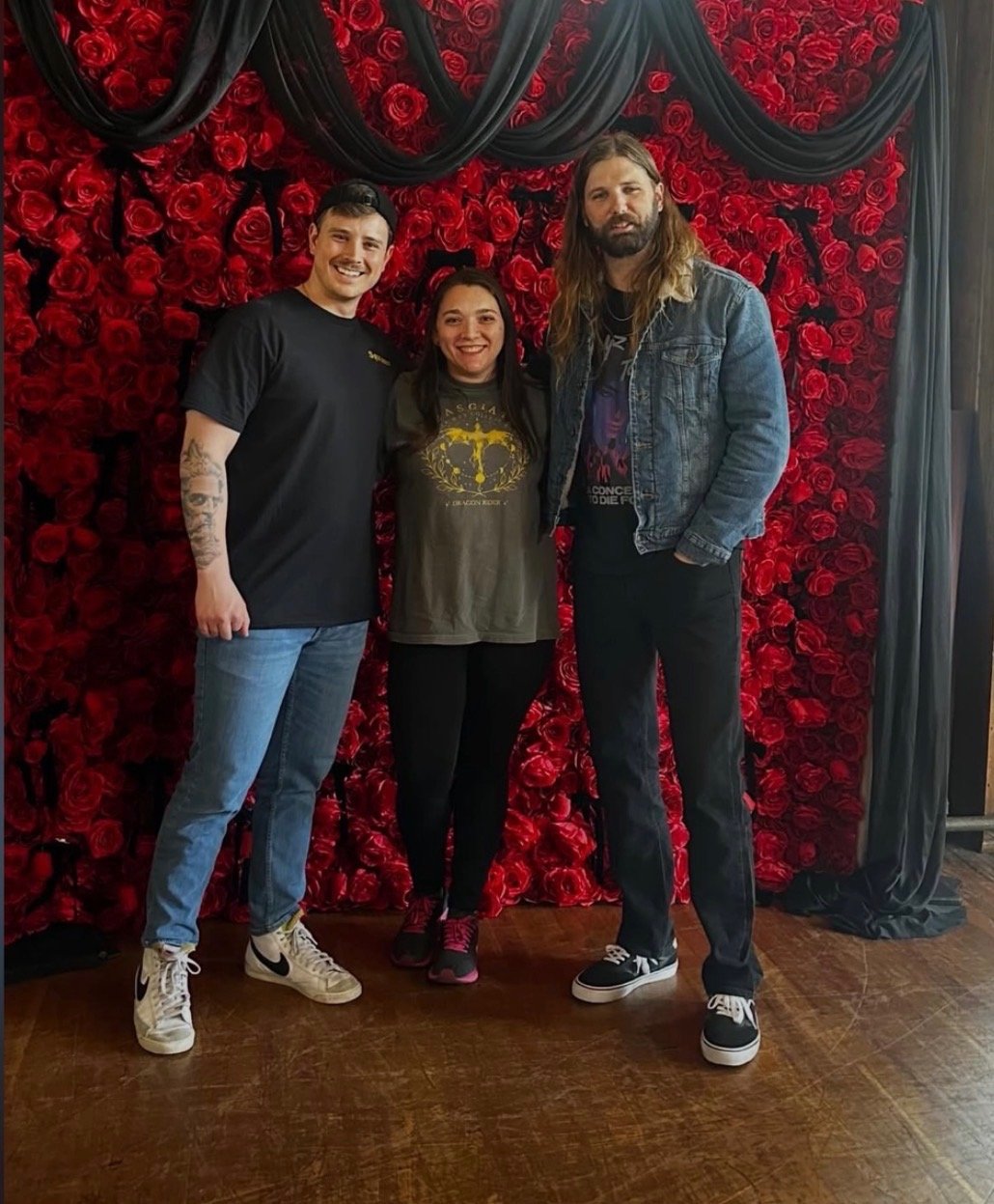 Photo moment in front of a red rose wall at Dragon Riders Weekend and Gala