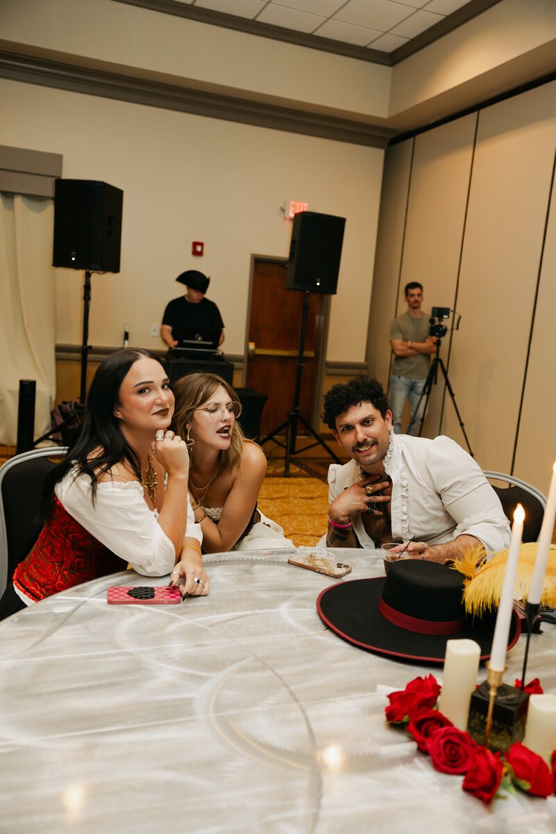 Three guests leaning toward the camera at a table during Phantoms of the Deep