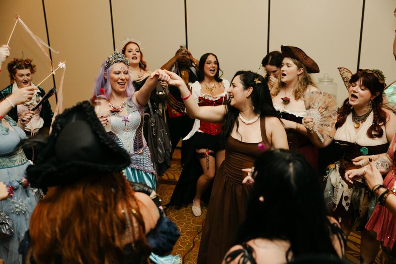 Costumed guests raising their hands during an interactive gathering at Phantoms of the Deep