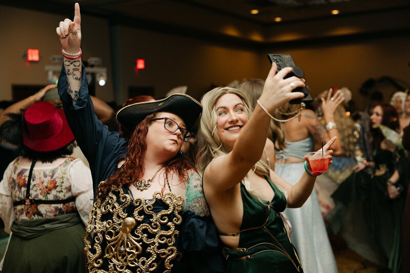 Two costumed guests taking a selfie on the dance floor at Phantoms of the Deep
