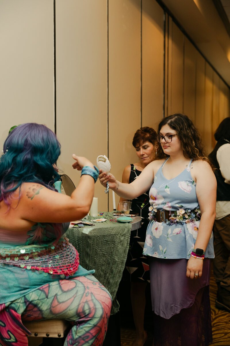 Three attendees gathered around an activity table at Phantoms of the Deep